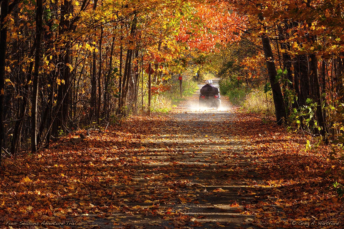 Autumn view of someone enjoying the Four Seasons Adventure Trail in Dexter, Maine