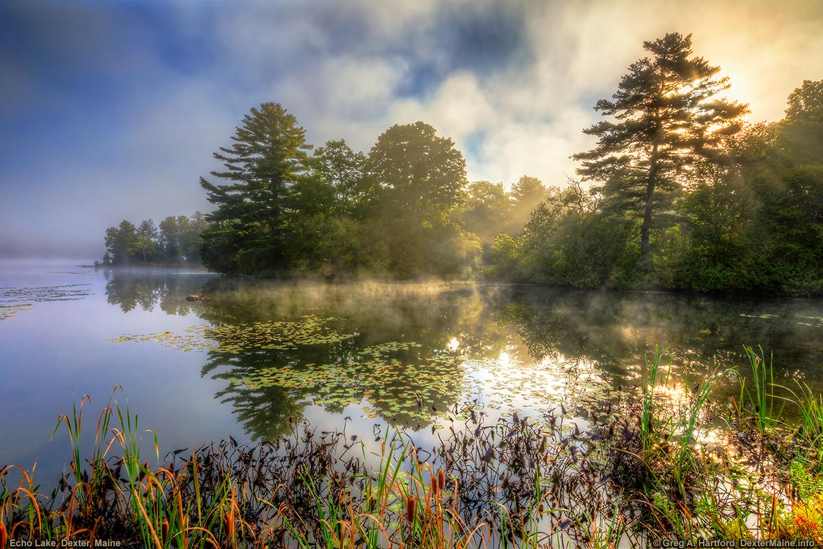 The sun breaks through the mist at Echo Lake in Dexter, Maine